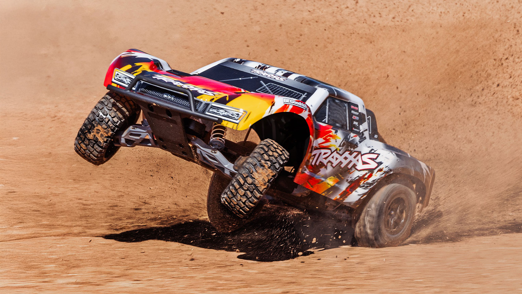Traxxas Slash 2WD carving through a dusty berm
